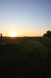 Picturesque view of beautiful countryside field at sunset