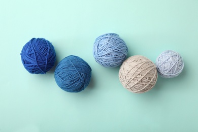 Soft colorful woolen yarns on light blue background, flat lay