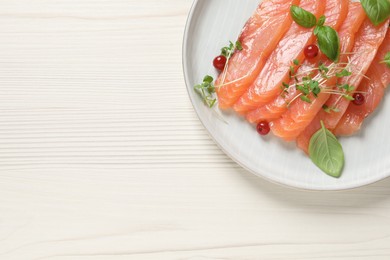Photo of Delicious salmon carpaccio served on white wooden table, top view. space for text