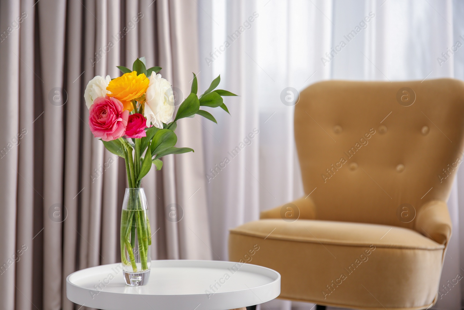 Photo of Vase with beautiful ranunculus flowers on table