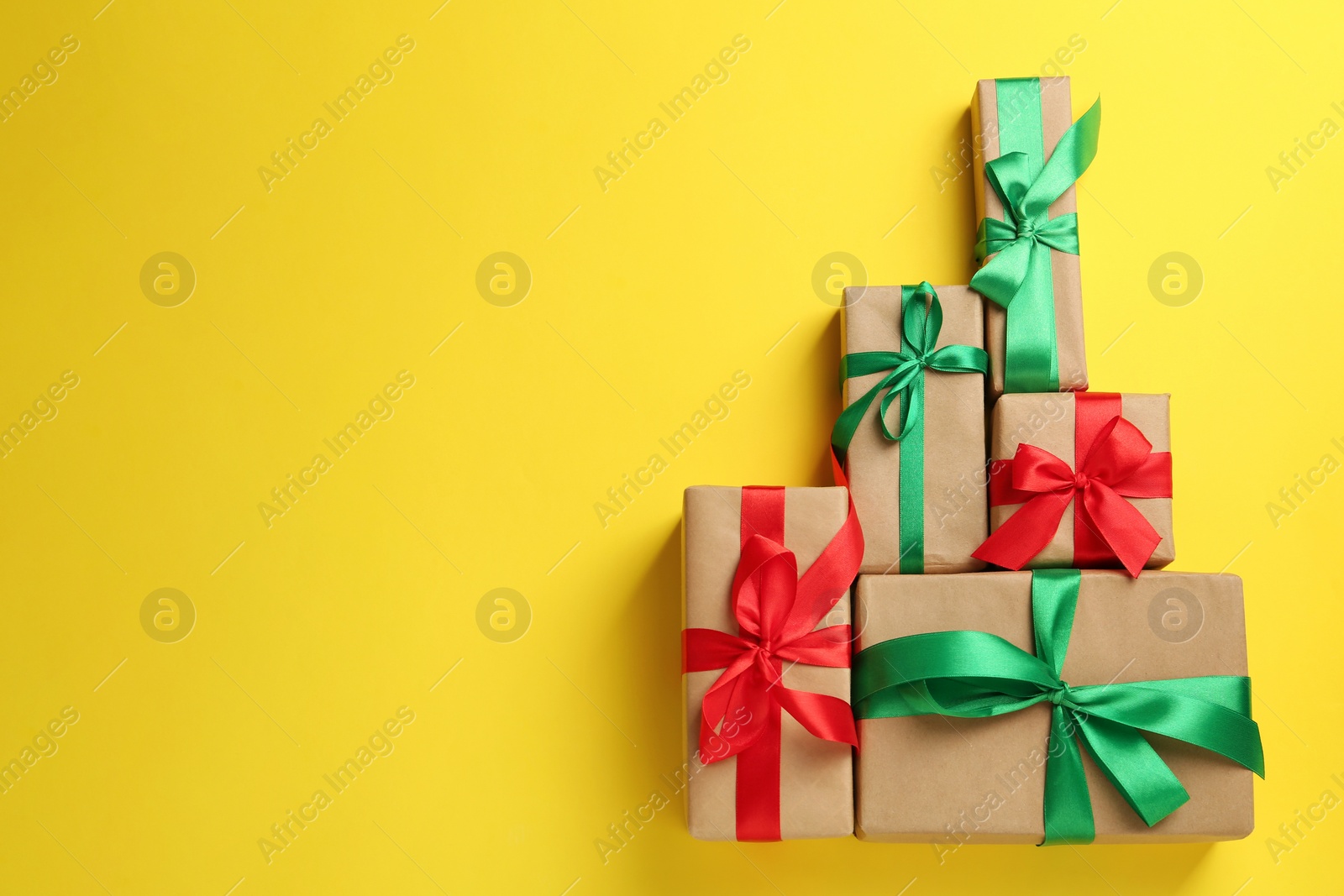 Photo of Many gift boxes on yellow background, flat lay. Space for text