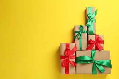 Photo of Many gift boxes on yellow background, flat lay. Space for text