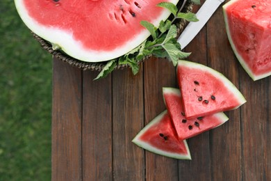 Tasty ripe watermelon on wooden table outdoors, flat lay