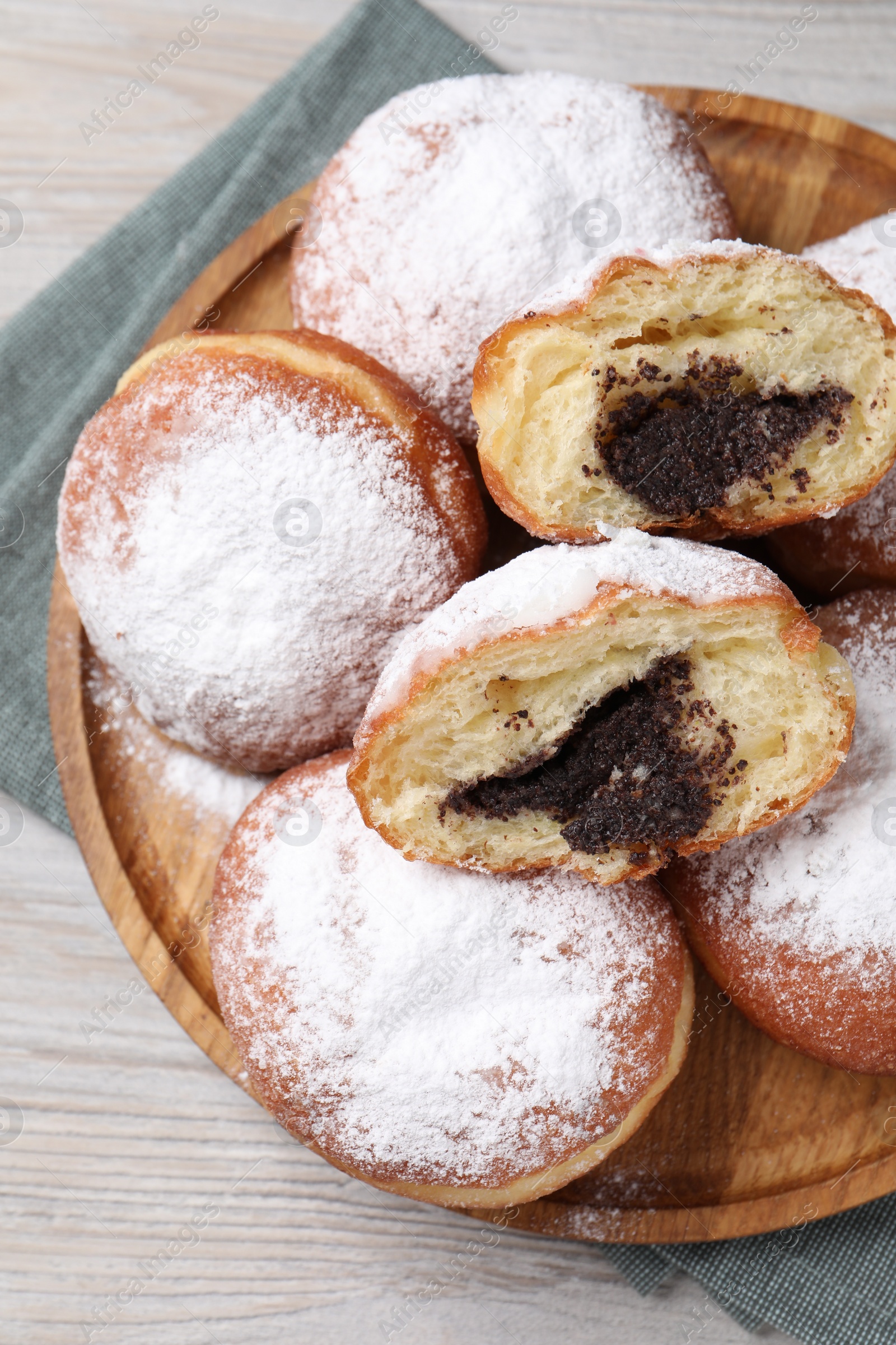 Photo of Delicious sweet buns with poppy seeds on light wooden table, top view