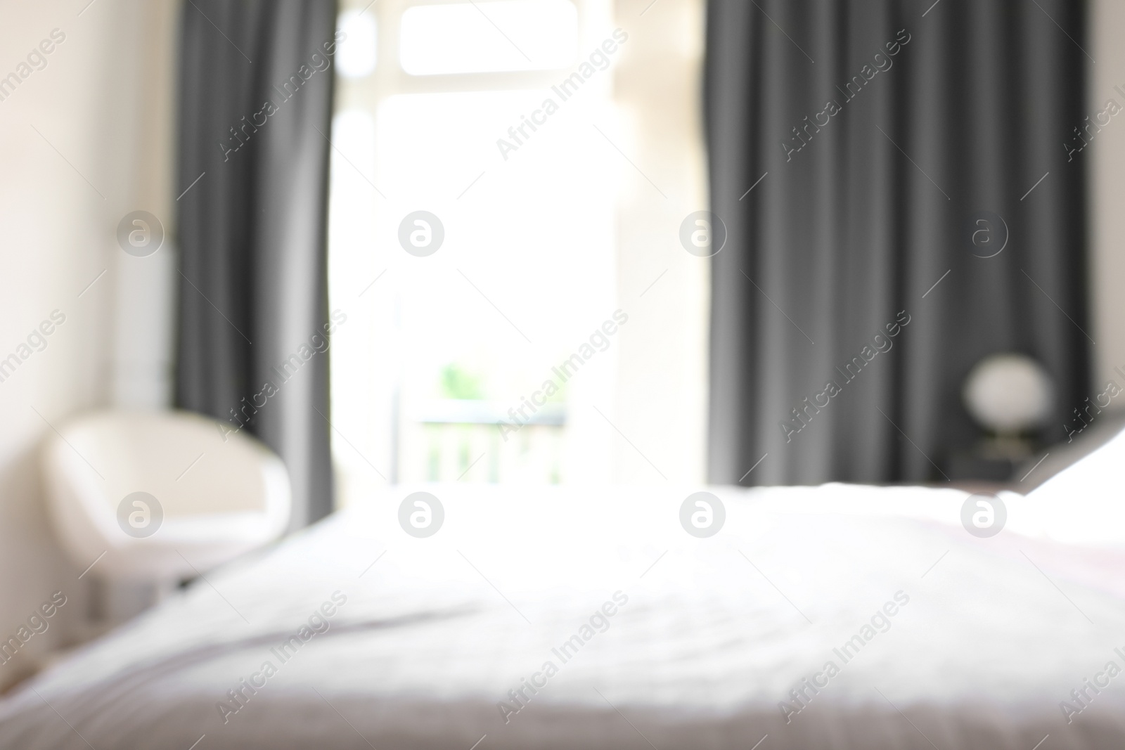 Photo of Blurred view of comfortable large bed in room