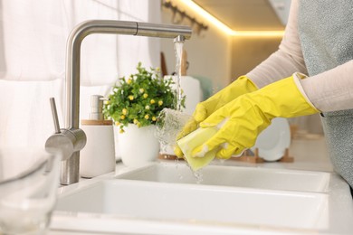 Photo of Housewife washing glass in kitchen sink, closeup