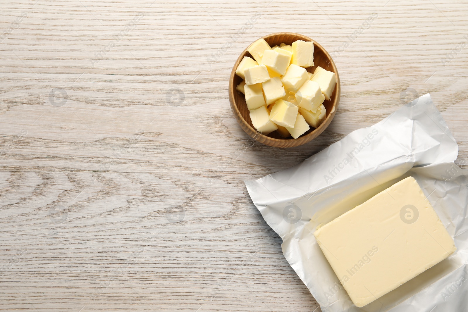 Photo of Tasty butter on light wooden table, flat lay. Space for text