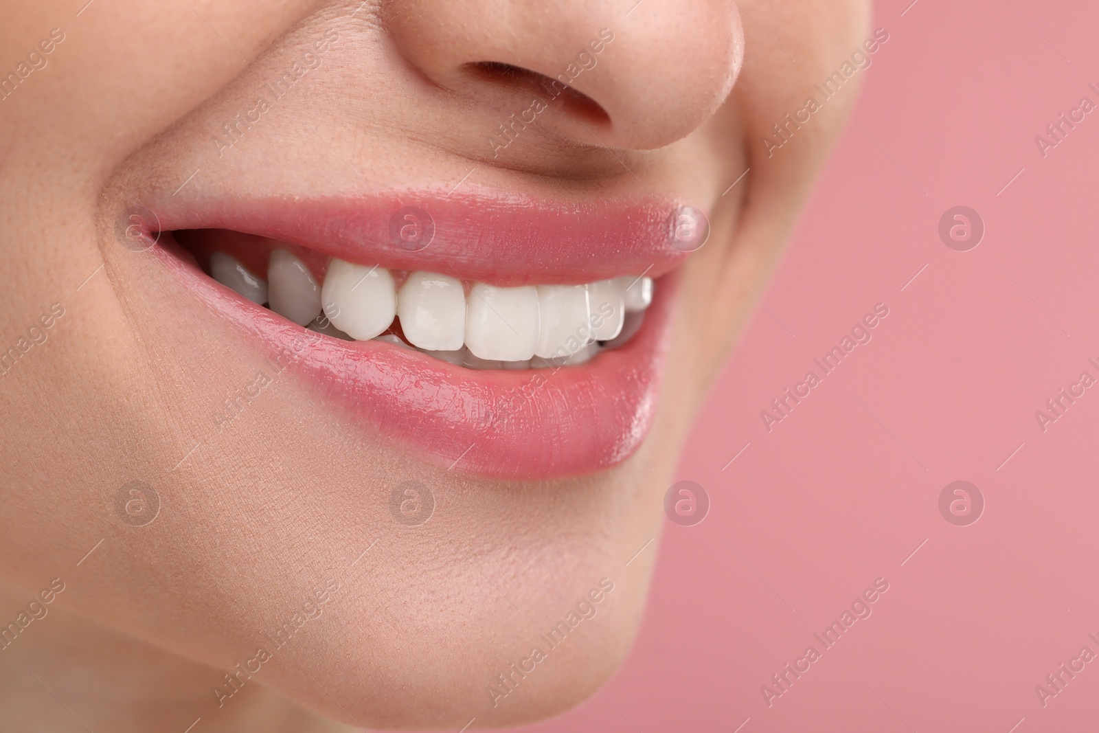 Photo of Young woman with beautiful smile on pink background, closeup