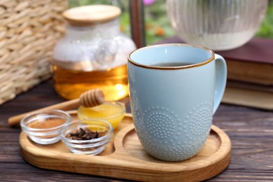 Photo of Tray with delicious tea and ingredients on wooden table, closeup. Space for text