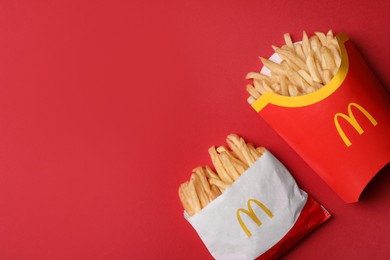 MYKOLAIV, UKRAINE - AUGUST 12, 2021: Small and big portions of McDonald's French fries on red background, flat lay. Space for text