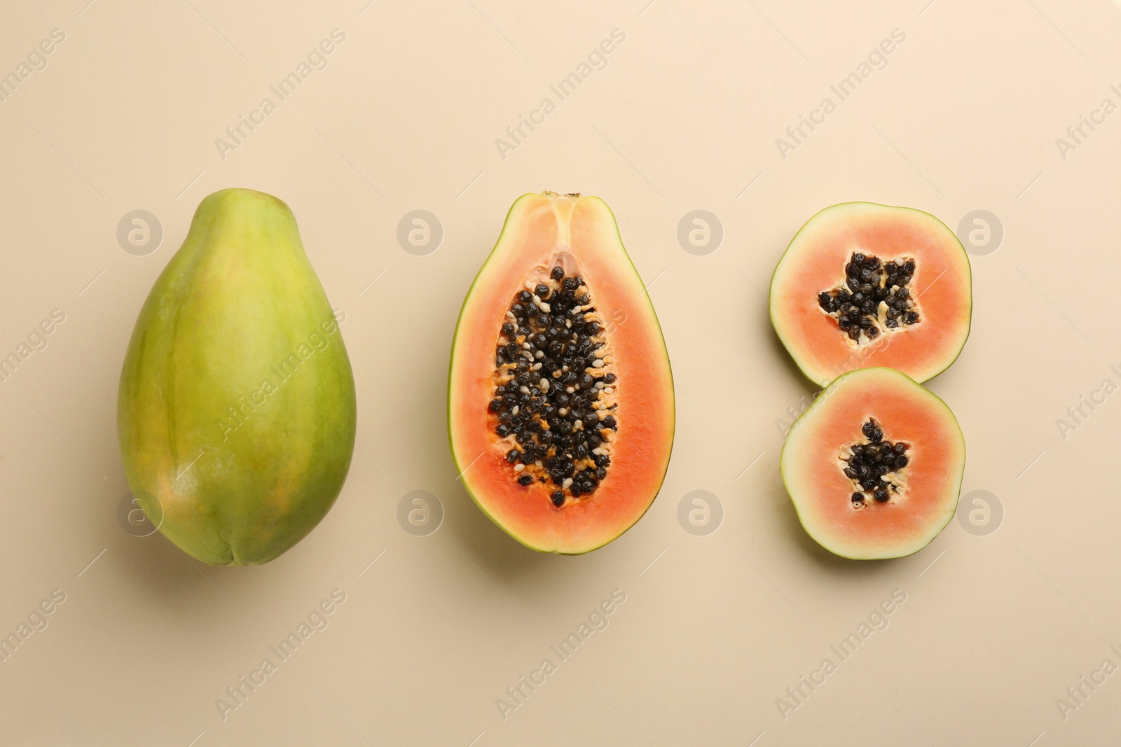 Photo of Fresh ripe papaya fruits on beige background, flat lay