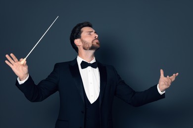 Professional conductor with baton on grey background