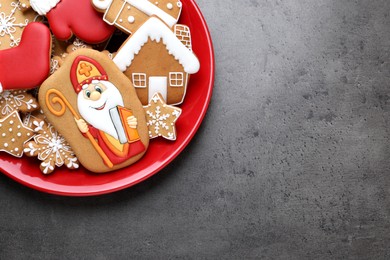 Photo of Tasty gingerbread cookies and space for text on grey table, top view. St. Nicholas Day celebration