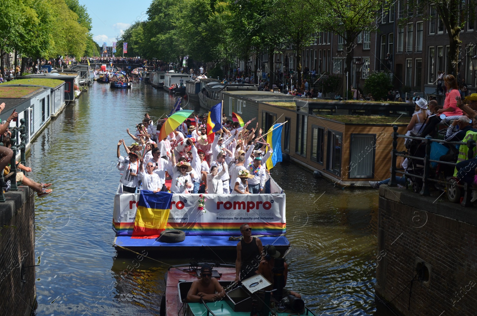 Photo of AMSTERDAM, NETHERLANDS - AUGUST 06, 2022: Many people in boats at LGBT pride parade on river