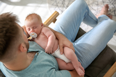 Photo of Father with his newborn son at home, above view