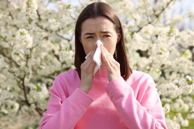 Photo of Woman with napkin suffering from seasonal allergy on spring day