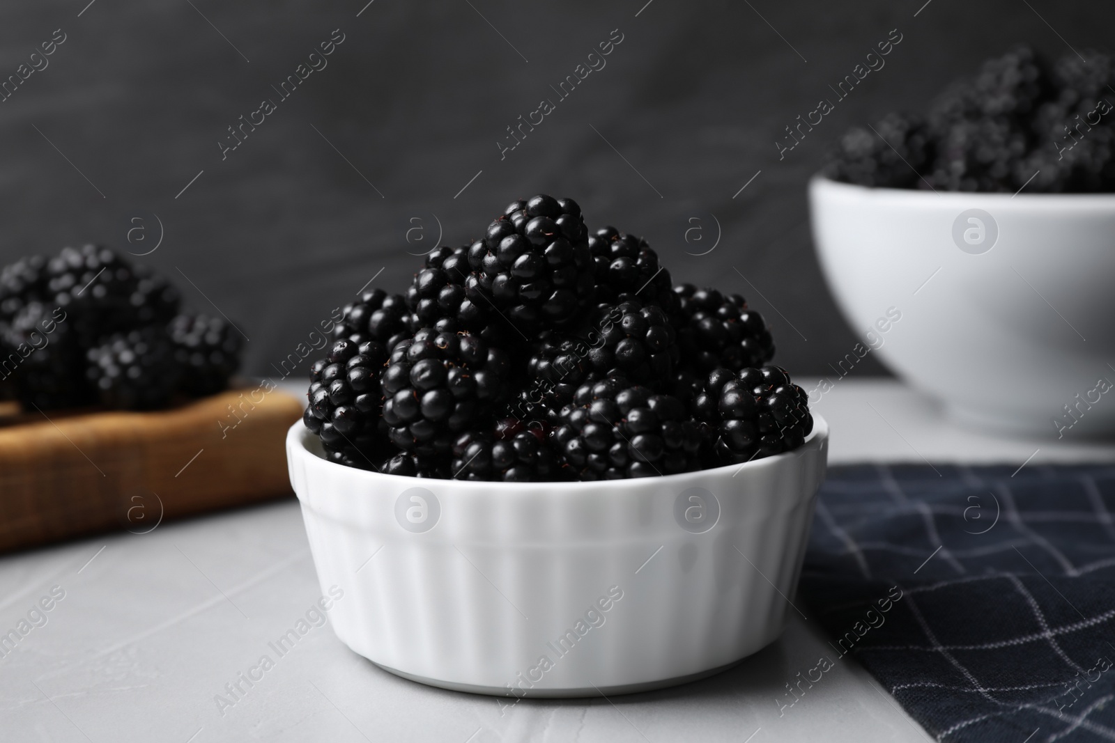 Photo of Delicious fresh ripe blackberries in bowl on table, closeup