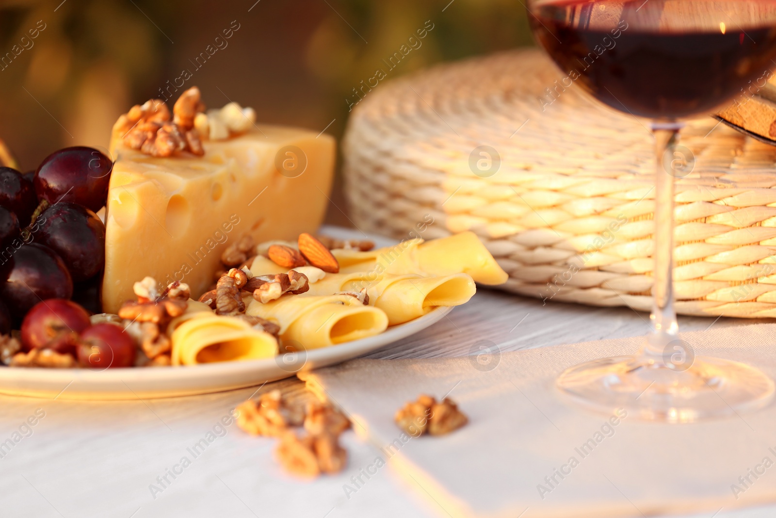 Photo of Composition with wine and snacks on white wooden table outdoors, closeup