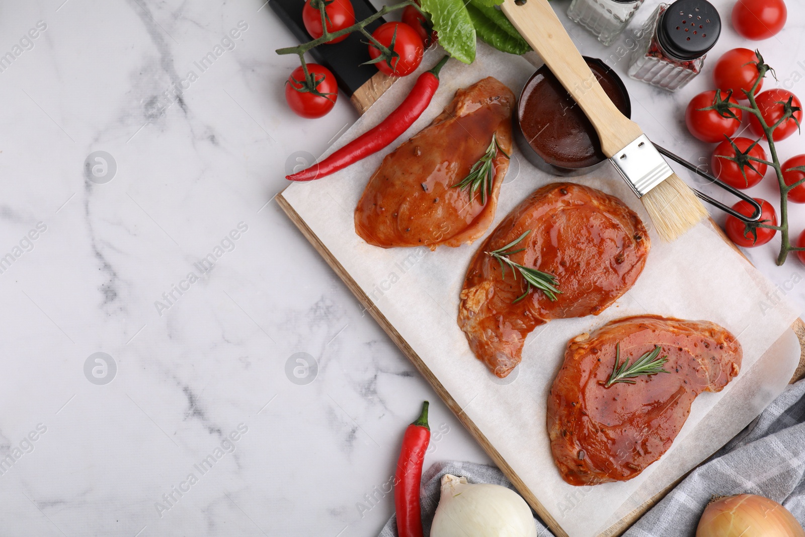 Photo of Flat lay composition with raw marinated meat, rosemary, basting brush and products on white marble table. Space for text