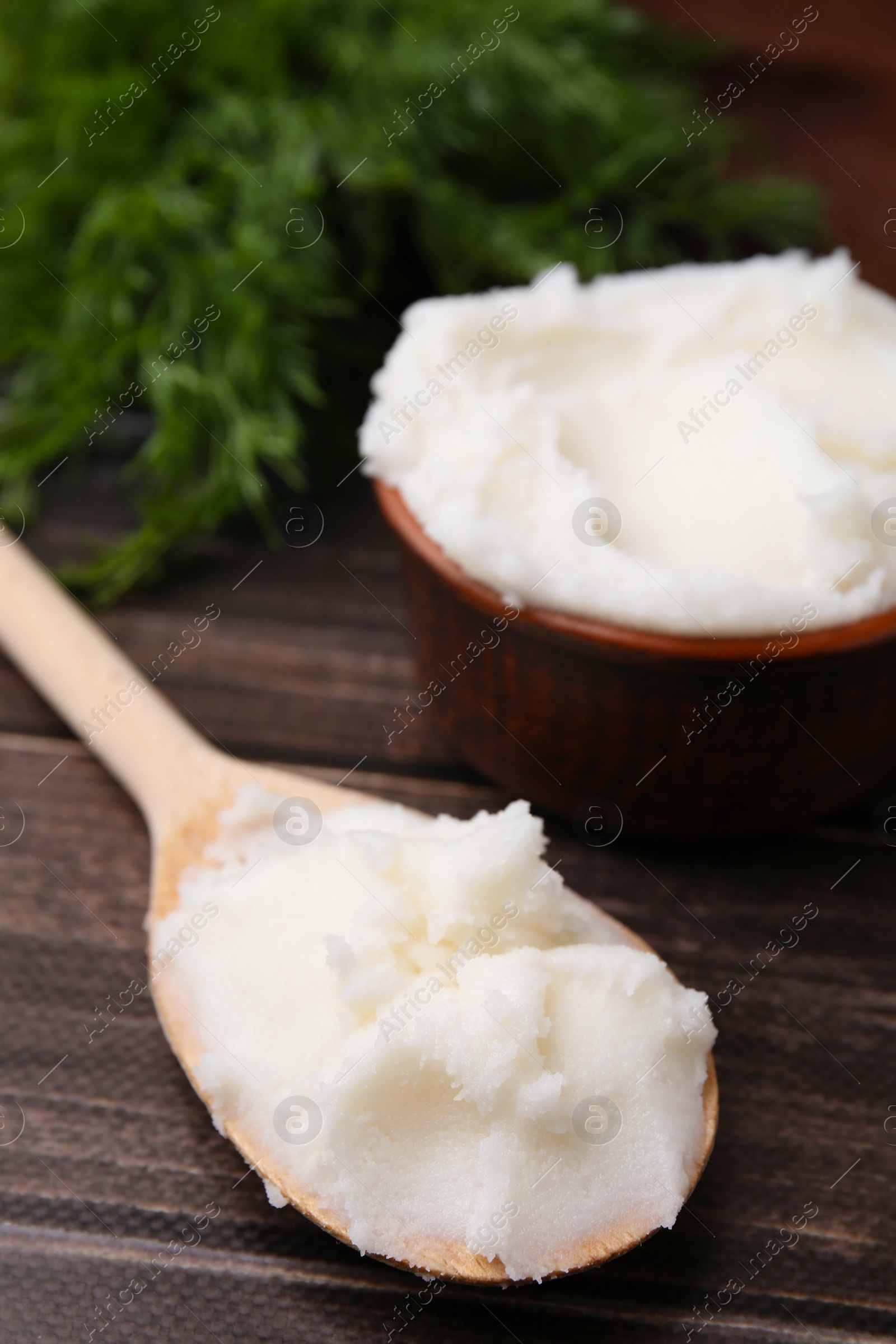 Photo of Spoon with delicious pork lard on wooden table, closeup