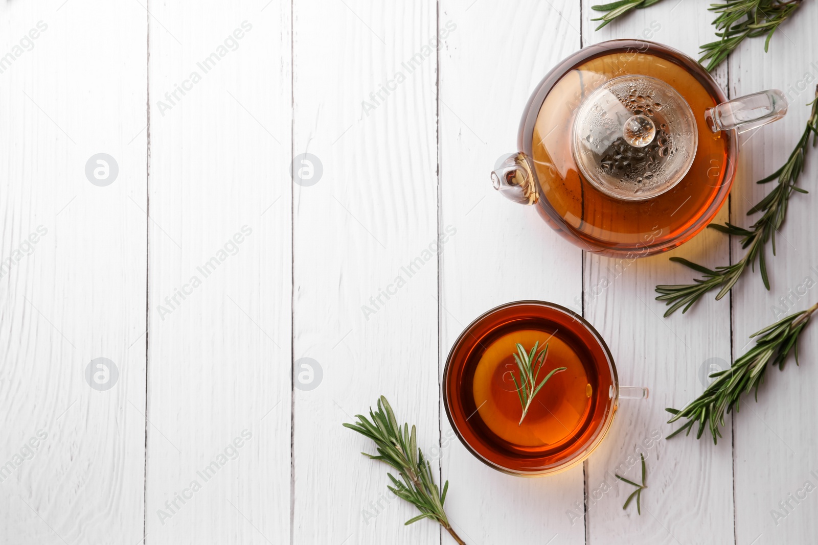 Photo of Aromatic herbal tea with rosemary on white wooden table, flat lay. Space for text