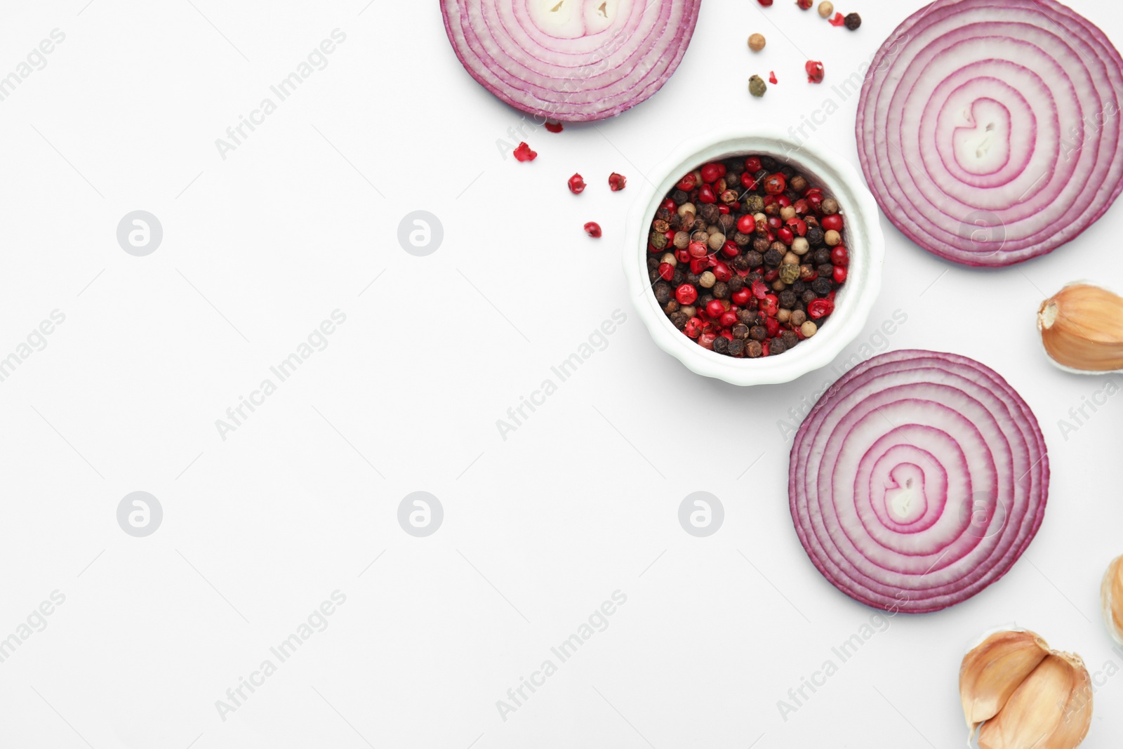 Photo of Fresh red onions, garlic, rosemary and spices on white background, flat lay. Space for text