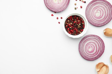 Photo of Fresh red onions, garlic, rosemary and spices on white background, flat lay. Space for text