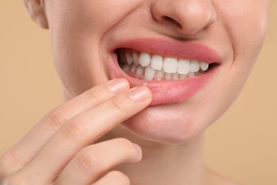 Photo of Woman showing her clean teeth on beige background, closeup