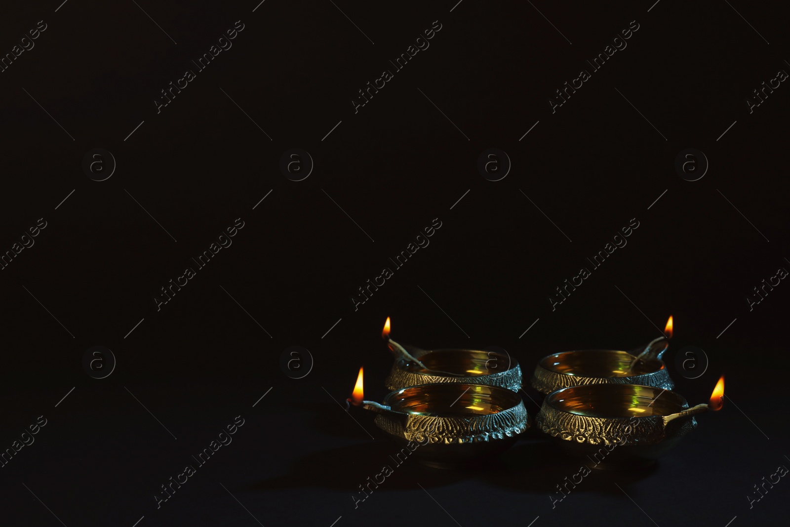 Photo of Diwali diyas or clay lamps on dark background