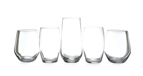 Photo of Set of different clean empty glasses isolated on white