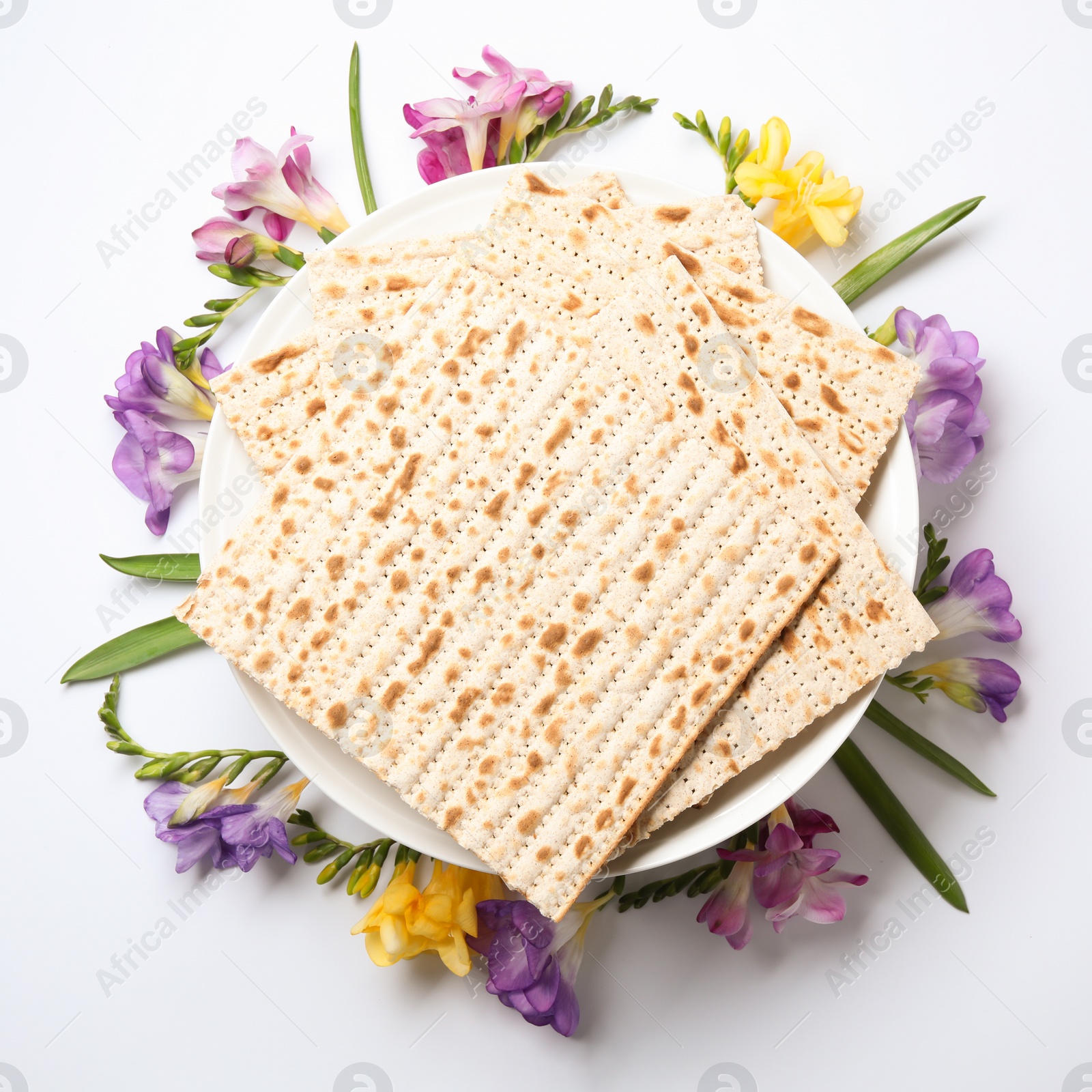 Photo of Composition of matzo and flowers on light background, top view. Passover (Pesach) Seder