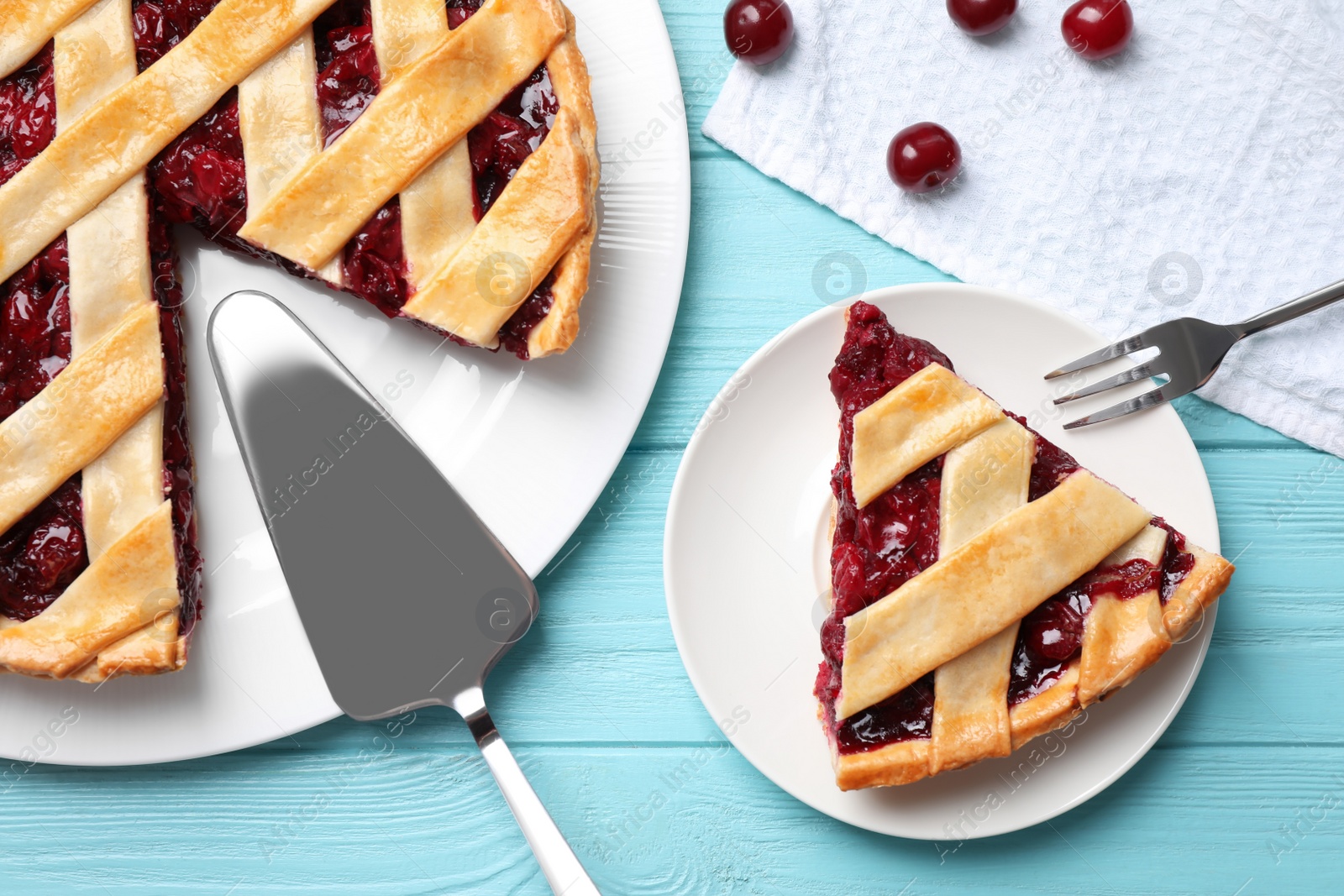 Photo of Delicious fresh cherry pie served on light blue wooden table, flat lay