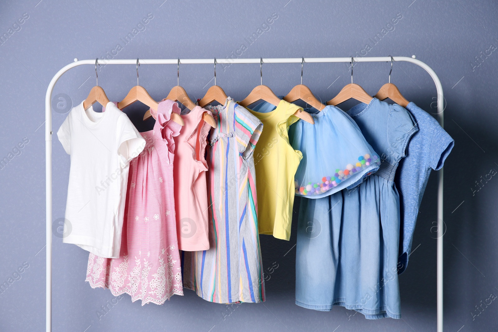 Photo of Rack with stylish child clothes on color background