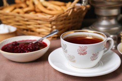 Photo of Aromatic tea and cherry jam on table, closeup. Space for text