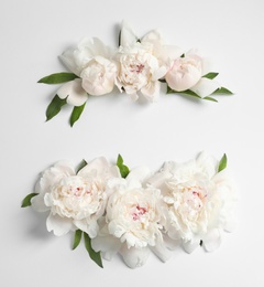 Flat lay composition with beautiful blooming peonies on white background