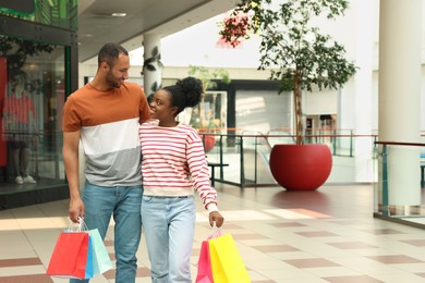 Family shopping. Happy couple with colorful bags in mall