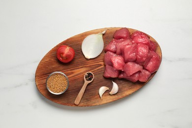 Photo of Raw beef meat and different ingredients for cooking delicious goulash on white marble table, top view