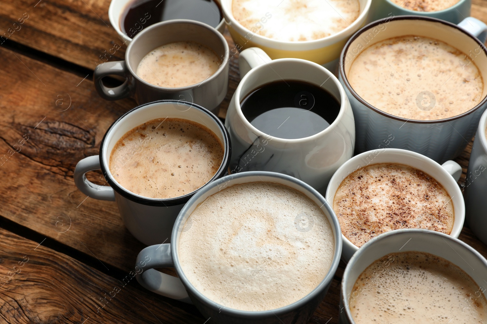 Photo of Many cups of different coffees on wooden table