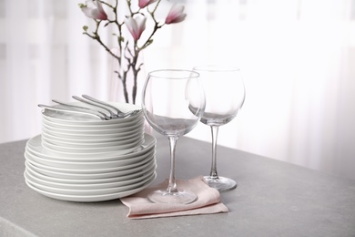 Photo of Set of clean dishes on table against blurred background