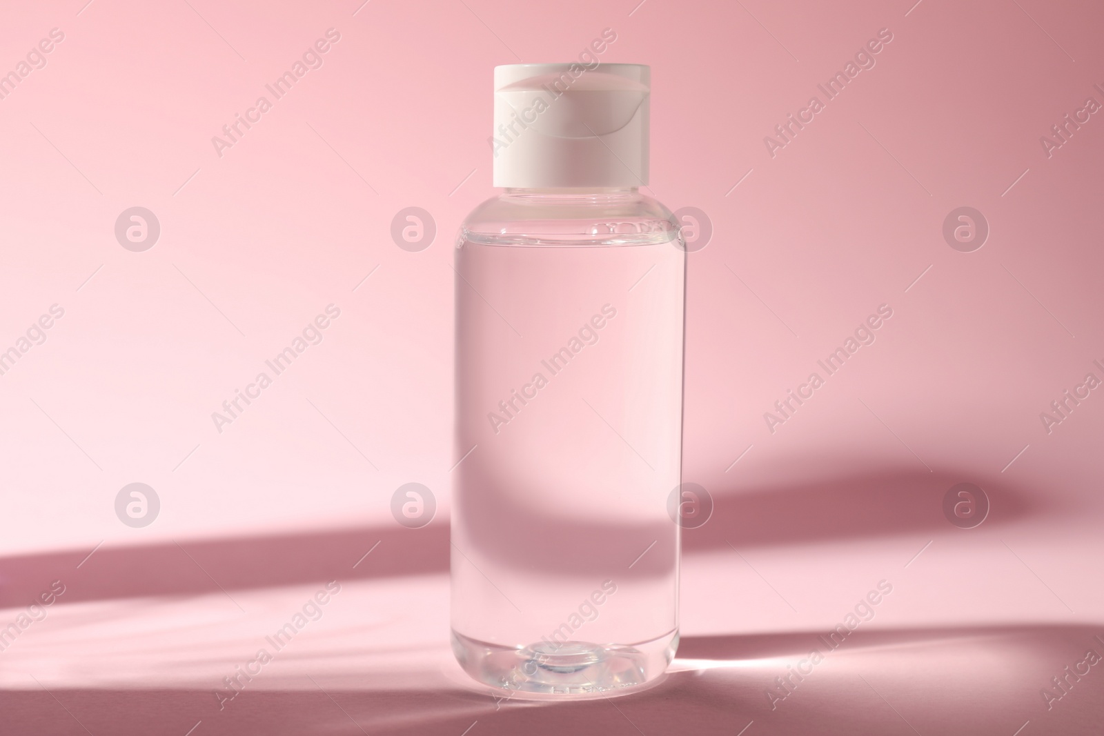 Photo of Bottle of micellar water on pink background