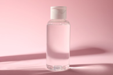 Photo of Bottle of micellar water on pink background