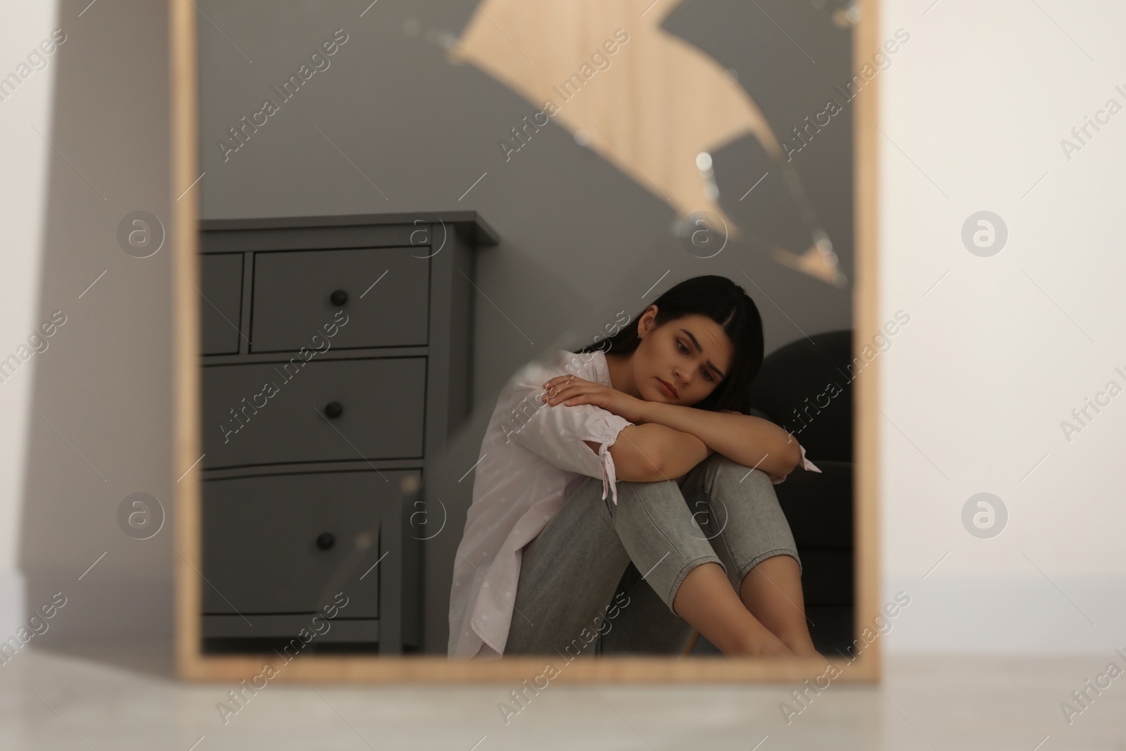 Photo of Mental problems. Depressed woman reflecting in broken mirror