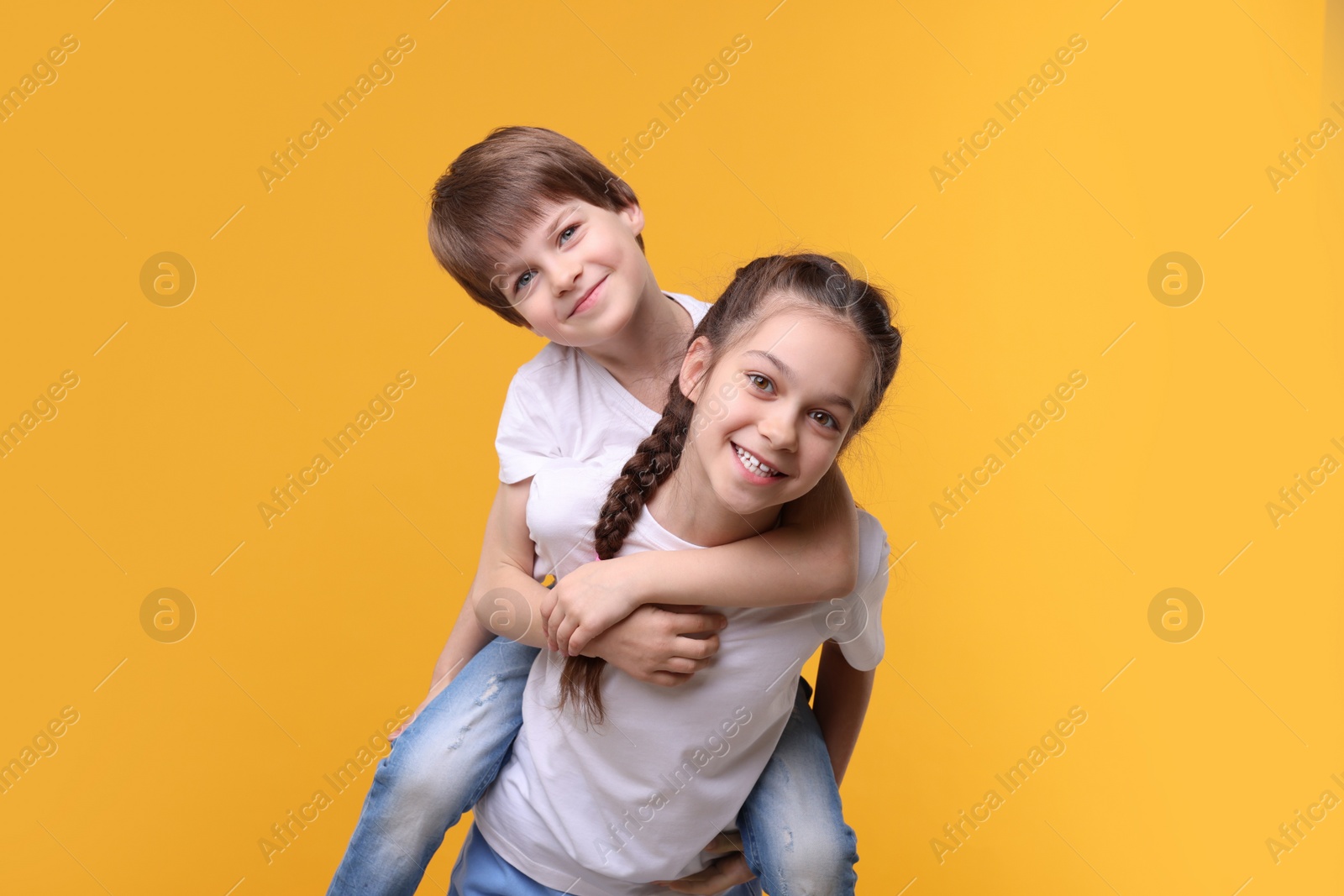 Photo of Happy brother and sister on orange background