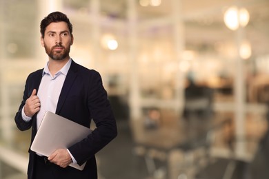 Successful lawyer with laptop on blurred background, space for text