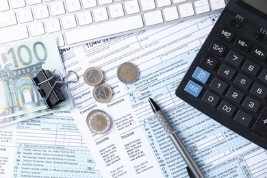 Photo of Tax accounting. Calculator, keyboard, money and stationery on documents, flat lay