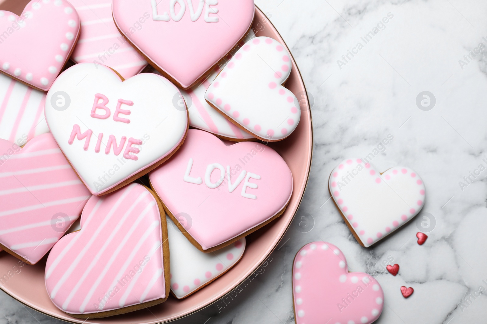Photo of Decorated heart shaped cookies on white marble table, flat lay. Valentine's day treat