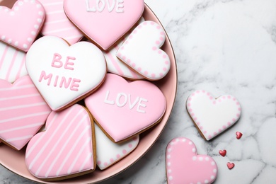 Photo of Decorated heart shaped cookies on white marble table, flat lay. Valentine's day treat