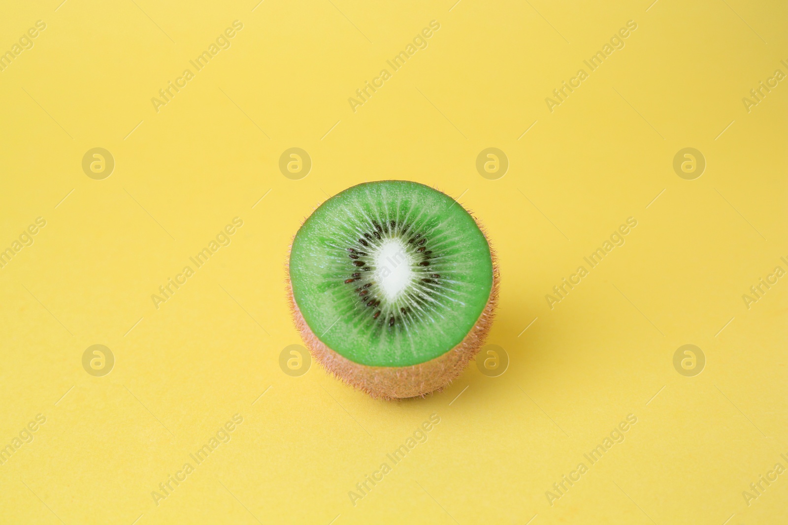 Photo of Cut fresh ripe kiwi on yellow background