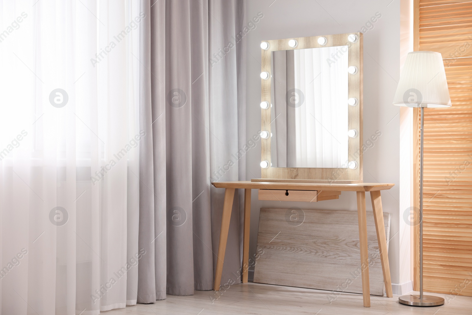 Photo of Beautiful mirror with light bulbs and lamp in makeup room