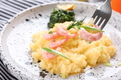 Photo of Eating of fresh tasty shrimp and grits, closeup